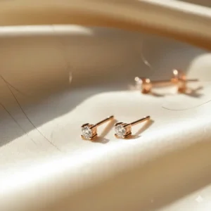 Dainty and petite 18k rose gold stud earrings, perfect for a second piercing.