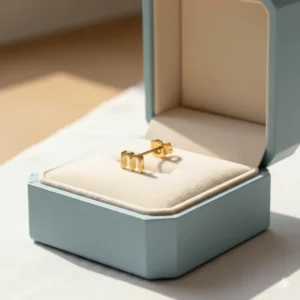 Personalized 14k gold stud earrings for girls featuring a small letter initial.