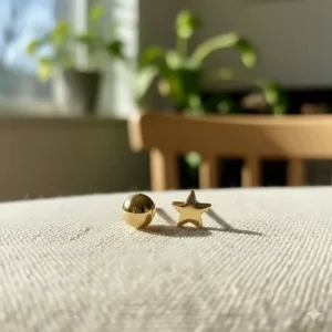 Studio shot of tiny 14k gold stud earrings with a shiny yellow gold finish.