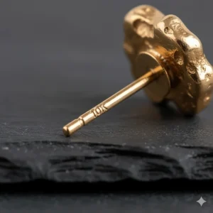 Extreme close-up of the 10k hallmark stamped on the post of the genuine gold nugget earrings, verifying the karat purity.