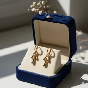 Luxury gold drop earrings presented in a velvet-lined jewelry gift box.