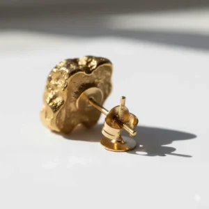 Gold nugget earrings placed next to a common item like a dime or penny for an accurate visual size comparison for customers.
