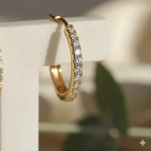 Macro close-up shot showing the pave diamond setting on gold huggie earrings.