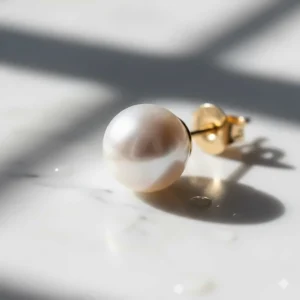 Macro view of freshwater pearl stud earrings demonstrating a smooth surface and high-grade reflective luster.