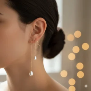 Delicate gold chain threader earrings with small teardrop-shaped pearls.