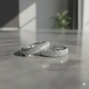 Close-up of pavé diamond huggie hoop earrings in white gold.