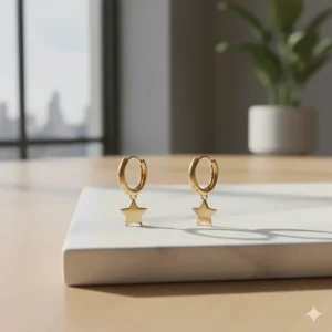 Gold huggie hoop earrings featuring a small removable star-shaped charm.