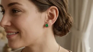 A woman wearing classic emerald stud earrings in gold for a sophisticated everyday look.
