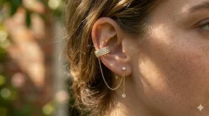 Sparkling cubic zirconia studded ear cuff with a dangling chain element.