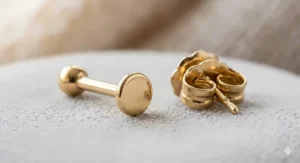 An illustration comparing a standard butterfly earring backing to a smooth flat back stud design for comfortable tragus earrings.